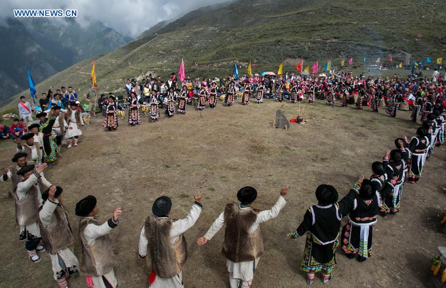 People of Qiang ethnic group dance in an event to worship the god 'Baihaha' in Xishan Village of Lixian County, southwest China's Sichuan Province, Sept. 20, 2015. 