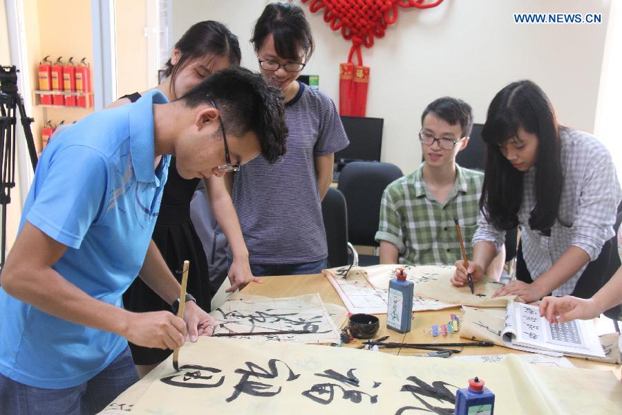 Vietnamese students from Hanoi University and Chinese overseas students practice Chinese calligraphy at the Confucius Institute of Hanoi University in Hanoi, Vietnam, Sept. 23, 2015. 