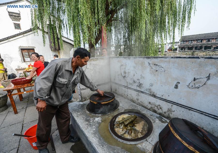 A villager cook a traditional food for the coming Mid-Autumn Festival in Tangxi Town of Hangzhou, east China's Zhejiang Province, Sept. 24, 2015.