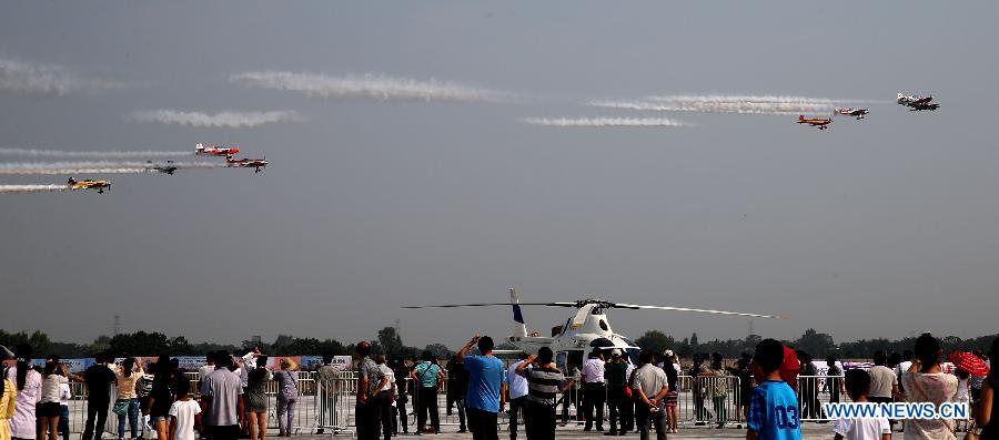 Visitors watch aerobatic performace at Zhengzhou Airshow 2015 in Zhengzhou, capital of central China's Henan Province, Sept. 25, 2015. 