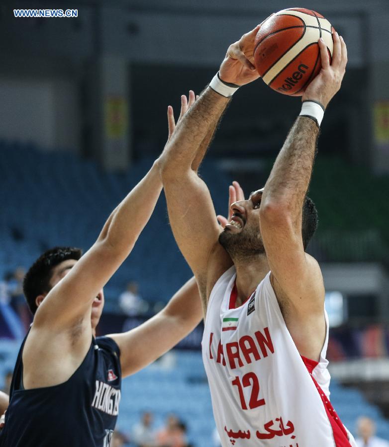 Asghar Kardoustpoustinsaraei (R) of Iran attempts to shoot during the second round match against Hongkong of China at 2015 FIBA Asia Champinship in Changsha, capital of central China's Hunan Province, Sept. 27, 2015. 