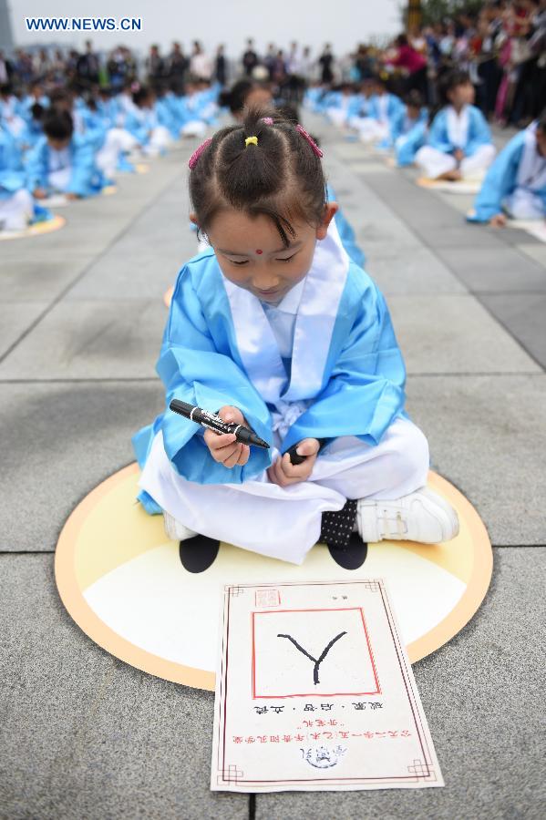 A girl writes a Chinese character during a first writing ceremony in Guiyang, capital of southwest China's Guizhou Province, Sept. 28, 2015.