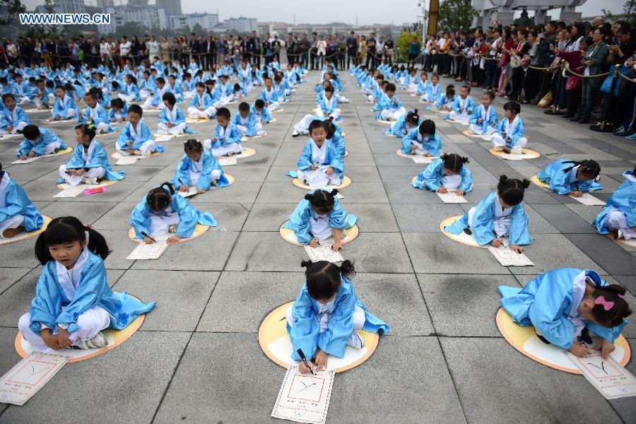Children write Chinese characters during a first writing ceremony in Guiyang, capital of southwest China's Guizhou Province, Sept. 28, 2015.