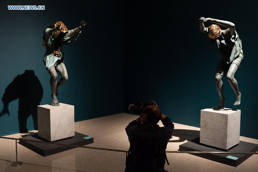 A visitor takes photos of sculpture works created by artist Anna Chromy in Beijing, capital of China, Oct. 12, 2015. 