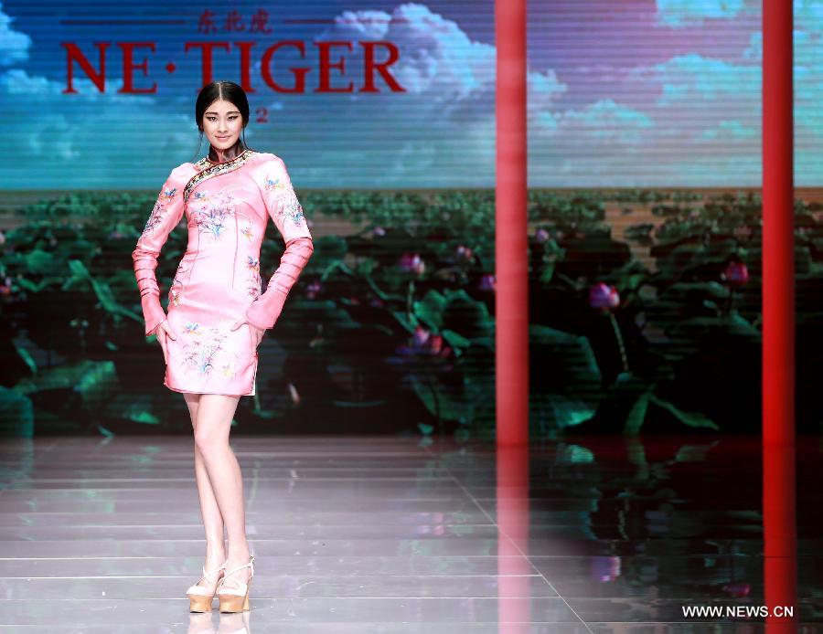 Models present creations by NE TIGER Haute Couture 2015 collection with the theme 'Qipao' during the opening show for the China Fashion Week in Beijing, capital of China, Oct. 25, 2015.