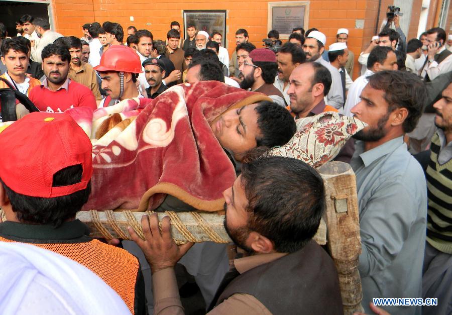 Pakistani people transfer an injured man to a hospital after a severe earthquake in northwest Pakistan's Peshawar on Oct. 26, 2015.