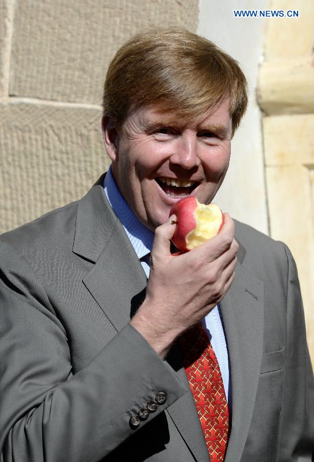 King of the Netherlands Willem-Alexander eats an apple cultivated by a local farmer at Fangta Village under Ansai County in Yan'an, northwest China's Shaanxi Province, Oct. 27, 2015. 