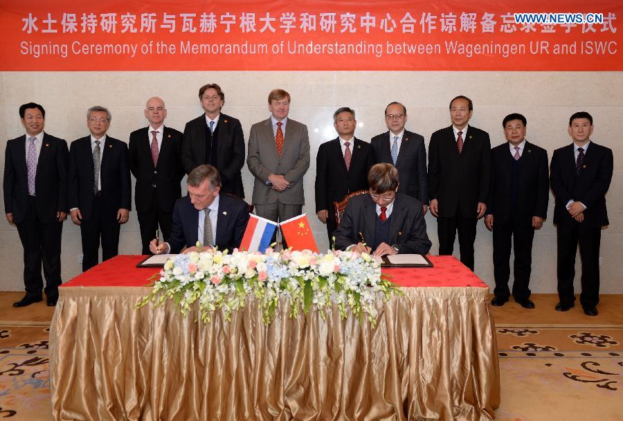 King of the Netherlands Willem-Alexander (5th L, rear) witnesses a signing ceremony of the memorandum of understanding between the Institute of Soil and Water Conservation under Chinese Academy of Sciences and Wageningen University and Research Center of Netherlands in Yan'an, northwest China's Shaanxi Province, Oct. 27, 2015.