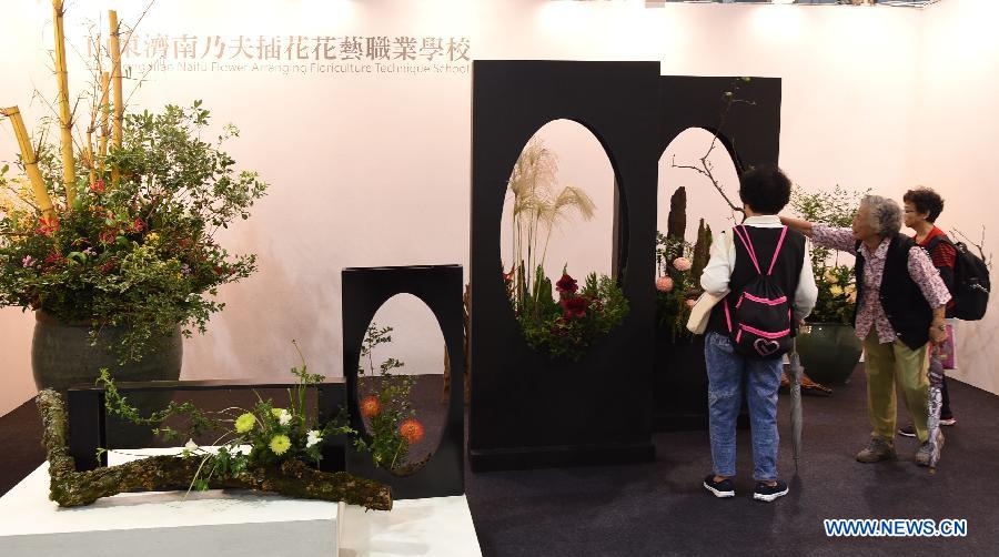 Local residents look at floral design by Naifu Flower Arranging Floriculture Technique School in Jinan, capital of east China's Shandong Province, at the 2015 Taipei International Flower Design Award show in Taipei, southeast China's Taiwan, Oct. 31, 2015. 