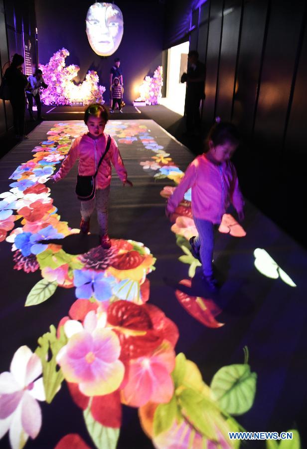 Children experience an interactive projection installation by a Taiwanese floral artist at the 2015 Taipei International Flower Design Award show in Taipei, southeast China's Taiwan, Oct. 31, 2015. 