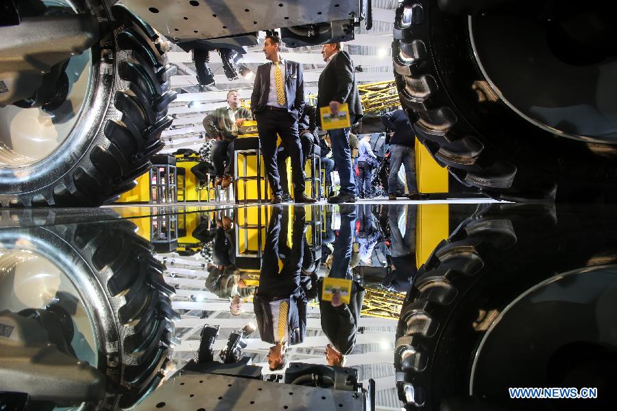 A boy plays in an operator cabin of an agricultural machinery model at Massey Ferguson's stand during the 2015 Agritechnica agricultural technology fair, in Hanover, Germany, Nov. 9, 2015.