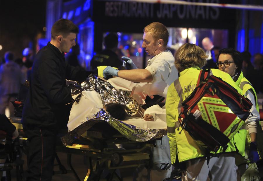 Wounded people are evacuated outside the scene of a hostage situation at the Bataclan theatre in Paris, 13 November 2015.