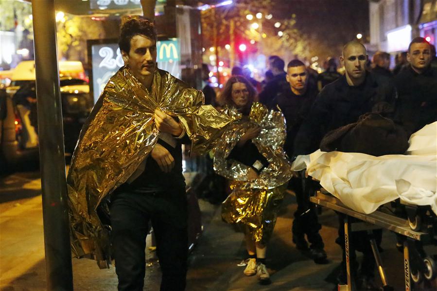 Wounded people are evacuated outside the scene of a hostage situation at the Bataclan theatre in Paris, 13 November 2015.
