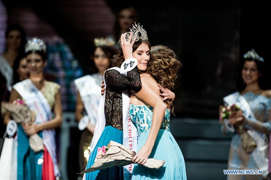 Grand-prix winner Alexandra Cherepanova (L) receives a crown of beauty queen from Tatiana Baitova, previous winner of beauty pageant 'Krasa Rossii-2014', during the beauty pageant 'Krasa Rossii-2015' in Moscow, Russia, on Nov. 17, 2015. 