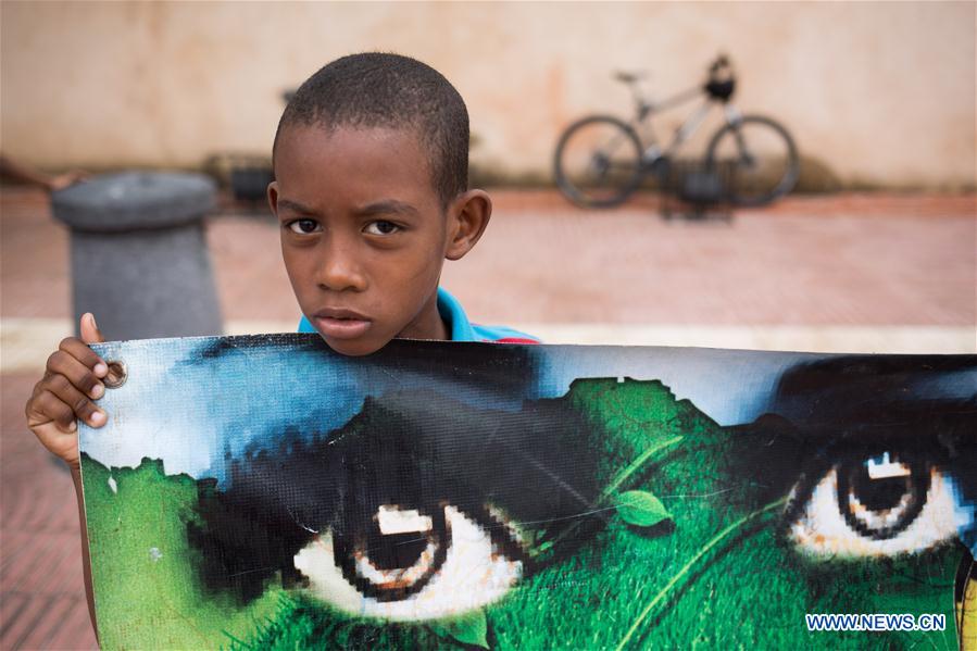 A boy holds a banner during a gathering in the Independence Park to support the Global Climate March in Santo Domingo, Dominican Republic, on Nov. 29, 2015. 