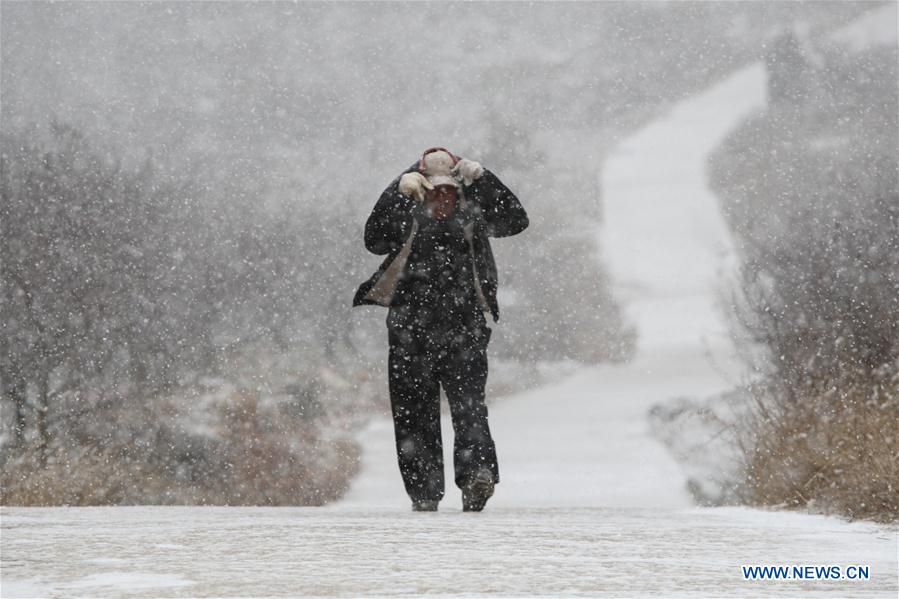 A man walks in heavy snow in Yantai, a coastal city of east China's Shandong Province, Dec. 16, 2015.