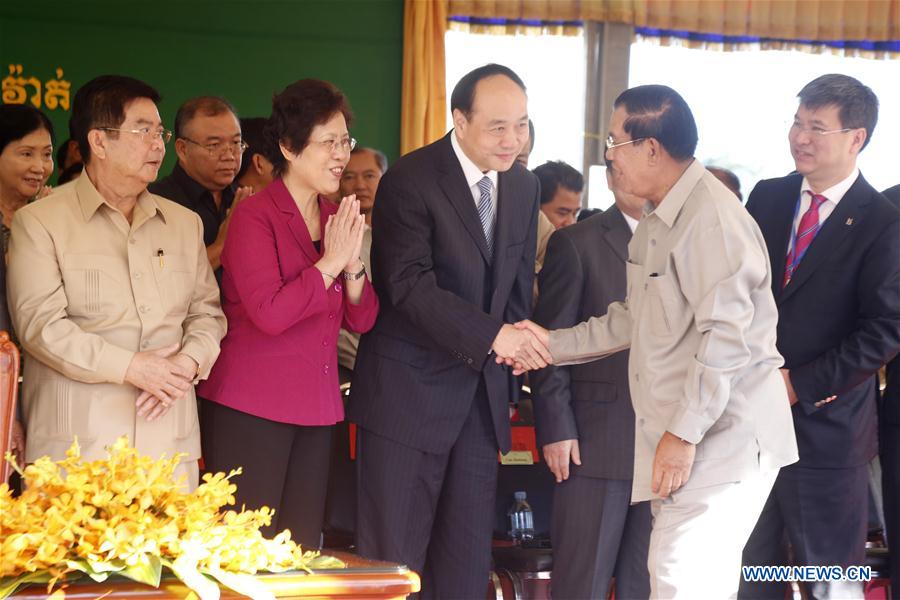 Cambodian Prime Minister Hun Sen (4th L, front) shakes hands with Shi Ke (3rd L, front), vice chairman of China National Machinery Industry Corporation, during the inauguration of the 246-megawatt Tatay River Hydropower Plant in Koh Kong province, Cambodia, Dec. 23, 2015.