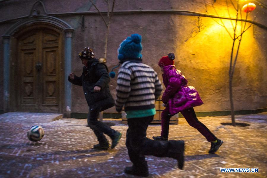 Children play football on a street in the old town of Kashgar, northwest China's Xinjiang Uygur Autonomous Region, Dec. 18, 2015.