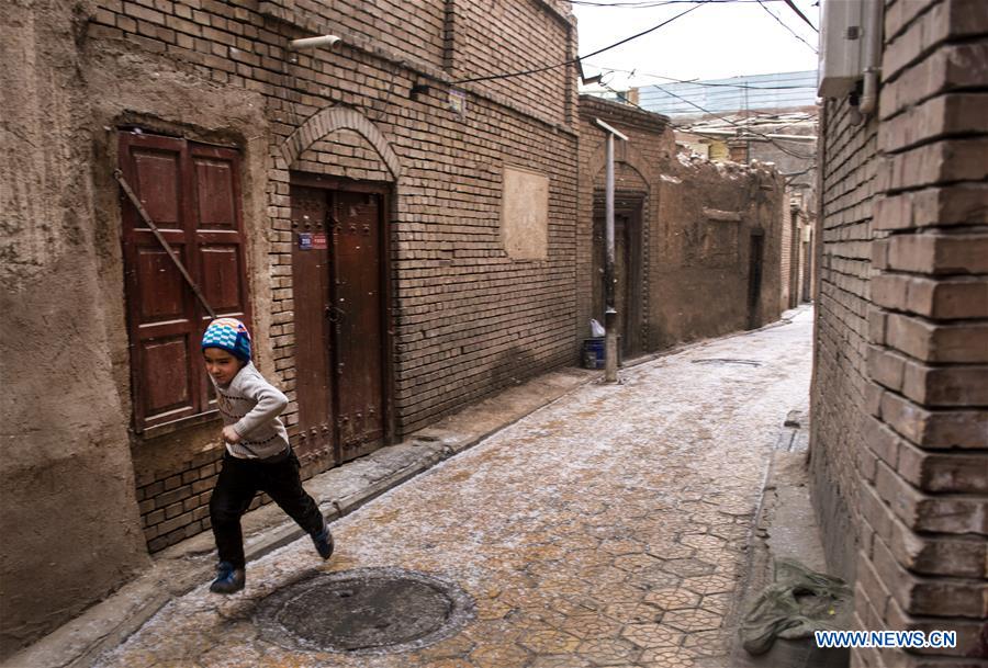 A boy runs on a street in the old town of Kashgar, northwest China's Xinjiang Uygur Autonomous Region, Dec. 19, 2015.