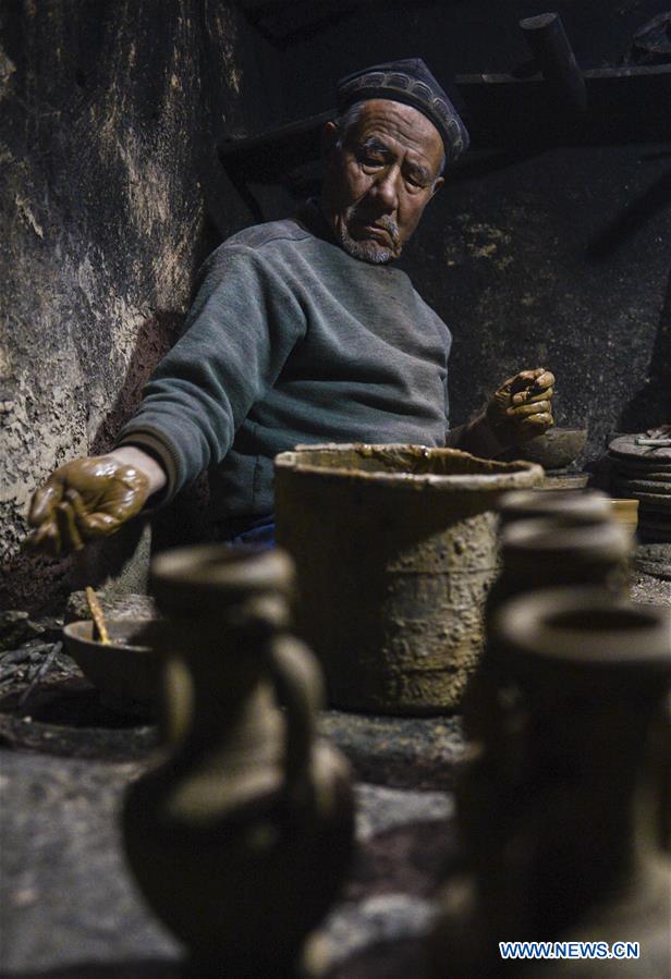 A local handicraftsman makes clay potteries at his home studio in the old town of Kashgar, northwest China's Xinjiang Uygur Autonomous Region, Dec. 17, 2015.