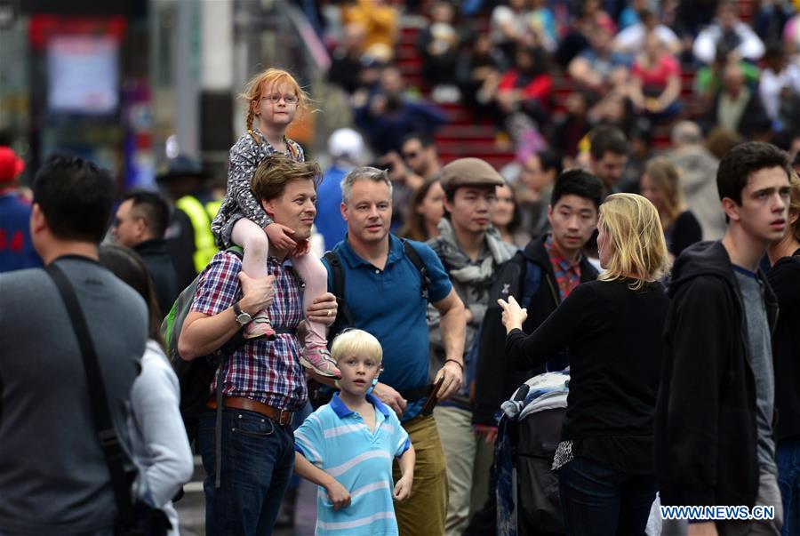 Tourists visit Times Square in New York City, the United States, on Dec. 24, 2015.