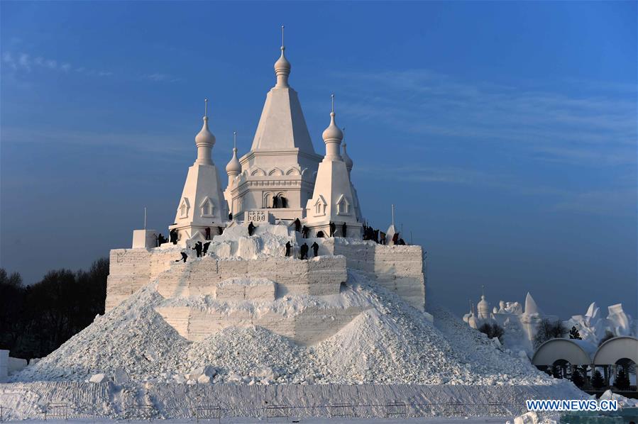 Snow sculptors work on a snow sculpture, which will be the highest in the world, in Taiyangdao, a small island in Harbin, northeast China's Heilongjiang Province, Dec. 24, 2015. 