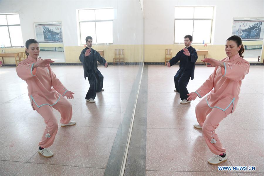 Paul Roberts (back) and Alicia Del Rio Cervera practise Taichi, a Chinese martial art, in Chenjiagou Village, where Taichi was originated, Wenxian County, central China's Henan Province, Dec. 24, 2015. 