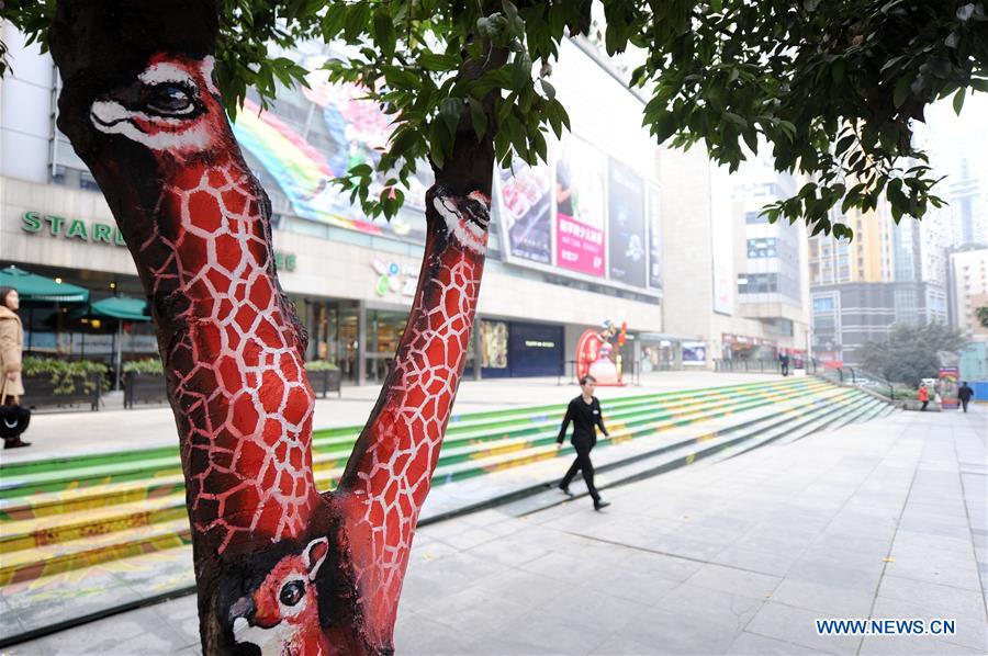 CHONGQING, Jan. 5, 2016 (Xinhua) -- A man walks on the city's first street which themed with graffiti arts over trees in southwest China's Chongqing Municipality, Jan. 5, 2016. (Xinhua/Tang Yi) 