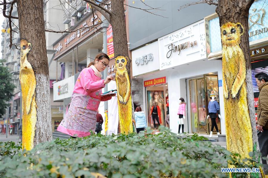 CHONGQING, Jan. 5, 2016 (Xinhua) -- A young artist paints on a tree along the first street which themed with graffiti arts in southwest China's Chongqing Municipality, Jan. 5, 2016. (Xinhua/Tang Yi) 