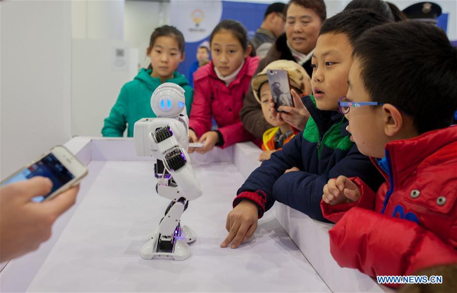 HOHHOT, Jan. 8, 2016 (Xinhua) -- Children stare at a dancing robot during a robot carnival in Hohhot, capital of north China's Inner Mongolia Autonomous Region, Jan. 8, 2016. A carnival was held here to invite younsters to come and engage high technology of modern robot. (Xinhua/Ding Genhou)