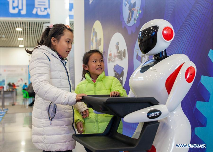 HOHHOT, Jan. 8, 2016 (Xinhua) -- Two girls interact with a robot during a robot carnival in Hohhot, capital of north China's Inner Mongolia Autonomous Region, Jan. 8, 2016. A carnival was held here to invite younsters to come and engage high technology of modern robot. (Xinhua/Ding Genhou)
