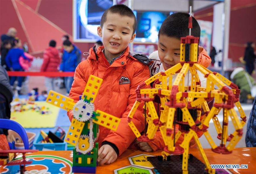 HOHHOT, Jan. 8, 2016 (Xinhua) -- Two boys focus on installing a robot during a robot carnival in Hohhot, capital of north China's Inner Mongolia Autonomous Region, Jan. 8, 2016. A carnival was held here to invite younsters to come and engage high technology of modern robot. (Xinhua/Ding Genhou)