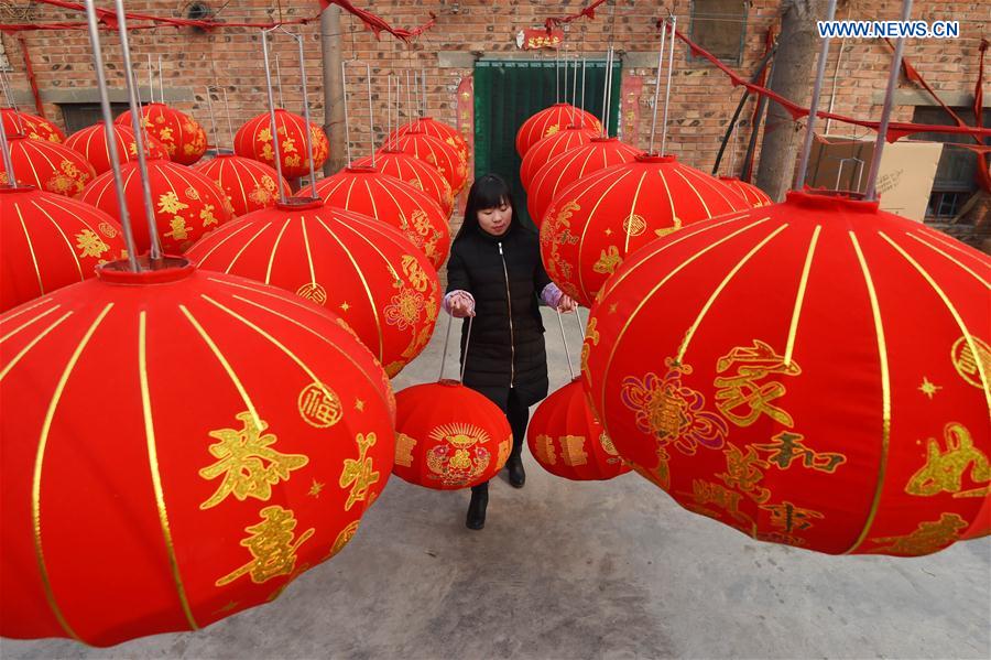 A villager dries newly-made red lanterns in Shijing Village of Wuzhi County, central China's Henan Province, Jan. 12, 2016.