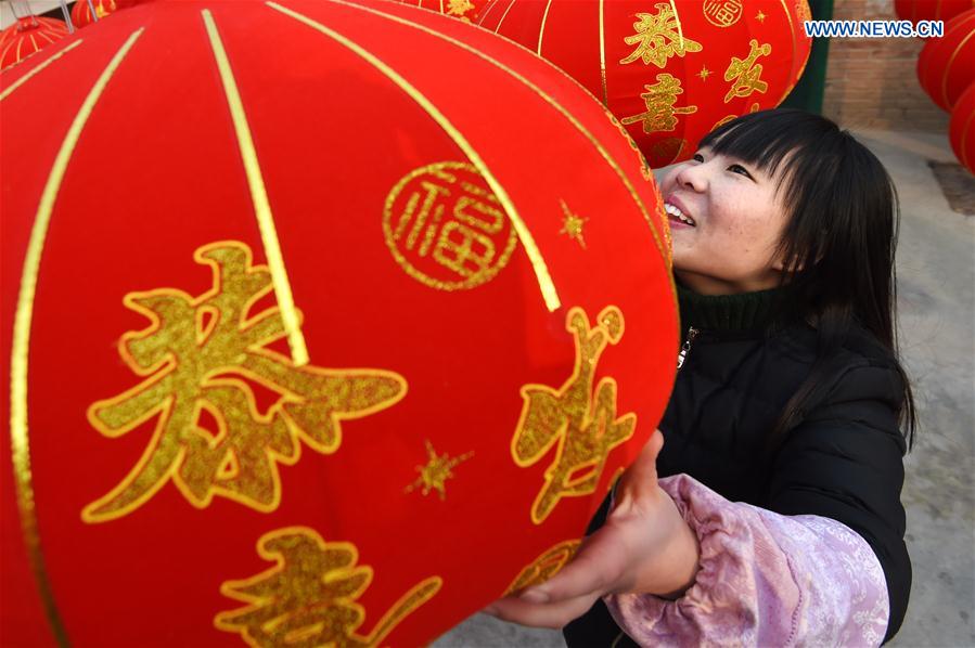 A villager dries newly-made red lanterns in Shijing Village of Wuzhi County, central China's Henan Province, Jan. 12, 2016. 