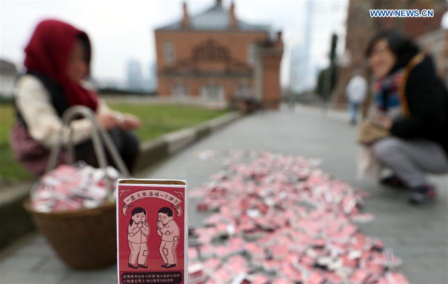 A match box is seen against the backdrop of the 'little match girl' at Waitan area in Shanghai, east China, Jan. 12, 2016.