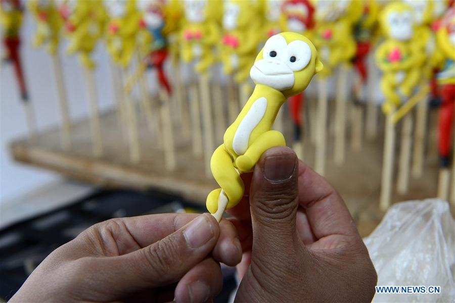 Li Jinguo, a dough modelling craftman, works on a dough figurine in Rizhao, east China's Shandong Province, Jan. 13, 2016.