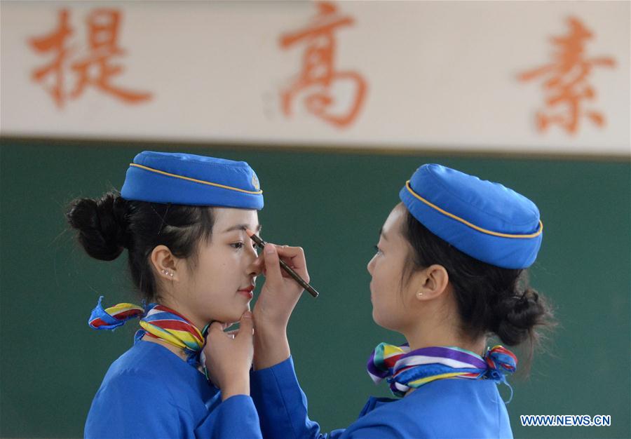 A student pencils the eyebrows for her classmate in training class at Bishan Vocational Education Center in Chongqing, southwest China, Jan. 13, 2016.