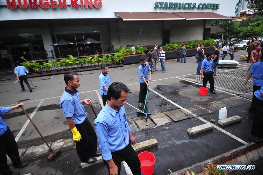 Workers clean the yard at the bombings and gun attacks site in Jakarta, Indonesia, Jan. 15, 2016.