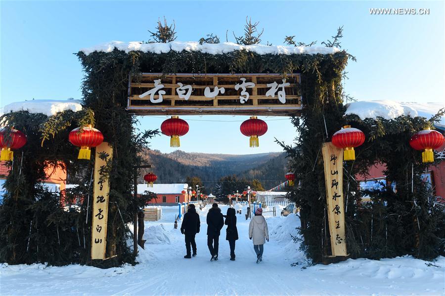 Tourists sightsee in Snow Village resort near Laobai Mountain in Dunhua, northeast China's Jilin Province, Jan. 14, 2016. 