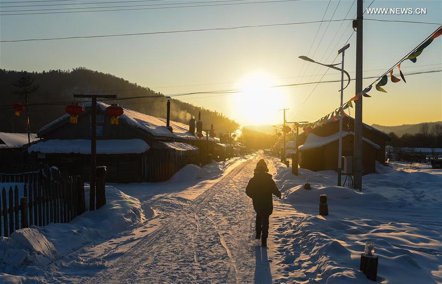 A tourist sightsees in Snow Village resort near Laobai Mountain in Dunhua, northeast China's Jilin Province, Jan. 14, 2016. 