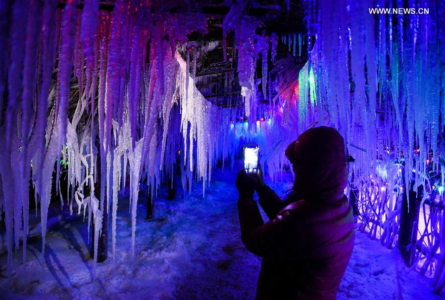 A tourist sightsees in Snow Village resort near Laobai Mountain in Dunhua, northeast China's Jilin Province, Jan. 14, 2016.