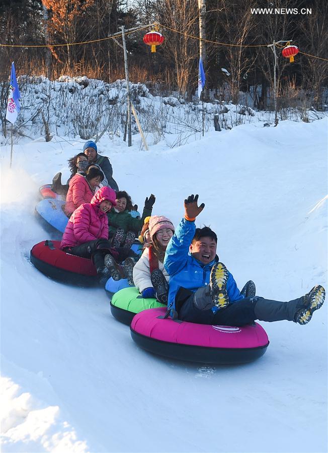 Tourists play in Snow Village resort near Laobai Mountain in Dunhua, northeast China's Jilin Province, Jan. 14, 2016.
