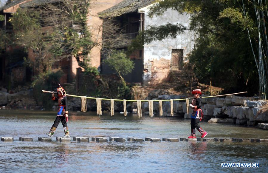 Residents carry sweet potato vermicelli to the drying feild at Qingxiang Village of Xinjie Town in Guilin City, a tourist resort in southwest China's Guangxi Zhuang Autonomous Region, Jan. 19, 2016.