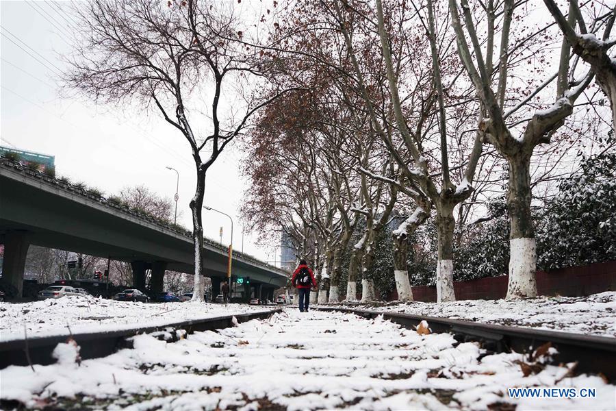 A man walks on a snow-covered road in Nanjing, capital of east China's Jiangsu Province, Jan. 21, 2016.