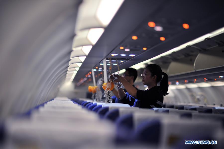 Staff members check oxygen masks inside a cabin at the maintenance base of China Southern Airlines in Haikou, capital of south China's Hainan Province, on Jan. 21, 2016.