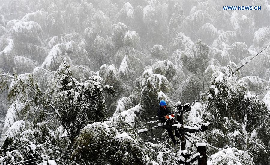 An electrician of local power grid tries to restore power supply in Xiaoshan district of Hangzhou, capital of east China's Zhejiang Province, Jan. 21, 2016