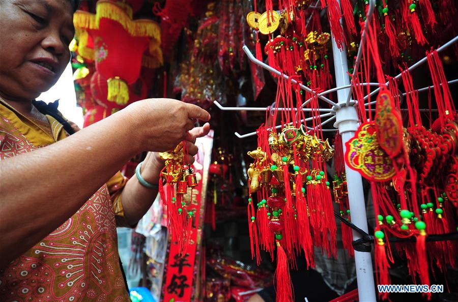 A customer selects decorations for Chinese New Year at a market in Jakarta, Indonesia, Jan. 25, 2016. 