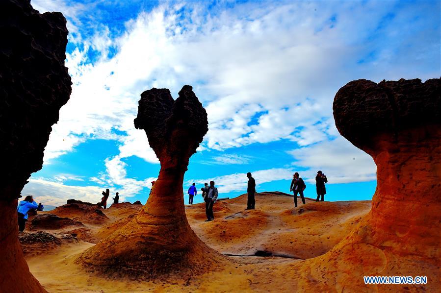 TAIPEI, Jan. 26, 2016 (Xinhua) -- Tourists visit Yehliu Geopark in New Taipei of southeast China's Taiwan, Jan. 26, 2016. The geopark features stunning geological landscape formed by wave attack, rock weathering, earth movement and crustal movement, which make it a famous destination for tourists. (Xinhua/Zhang Guojun) 
