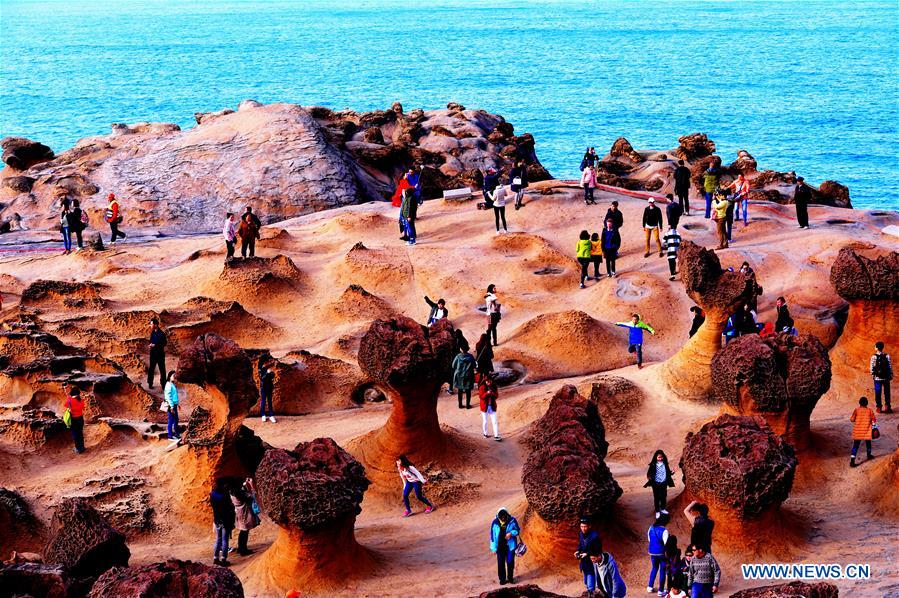 TAIPEI, Jan. 26, 2016 (Xinhua) -- Tourists visit Yehliu Geopark in New Taipei of southeast China's Taiwan, Jan. 26, 2016. The geopark features stunning geological landscape formed by wave attack, rock weathering, earth movement and crustal movement, which make it a famous destination for tourists. (Xinhua/Zhang Guojun) 