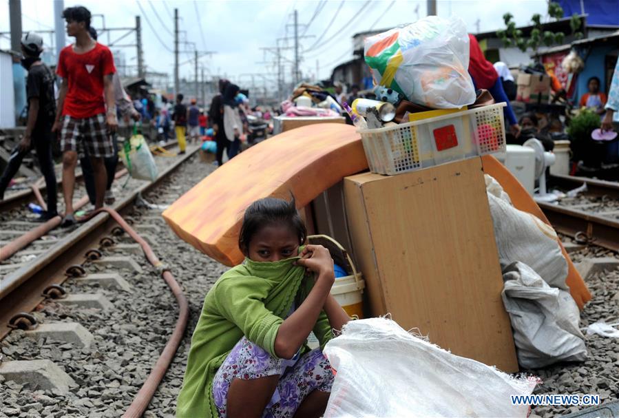 A firefighter drinks water after extinguishing a fire on semi-permanent houses at a slum area in Jakarta, Indonesia, Jan. 26, 2016.